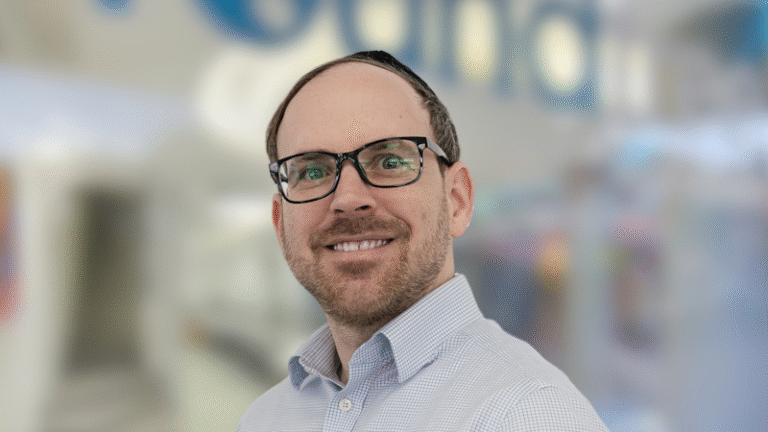 Matthew Round Headshot with office background 1 768x432